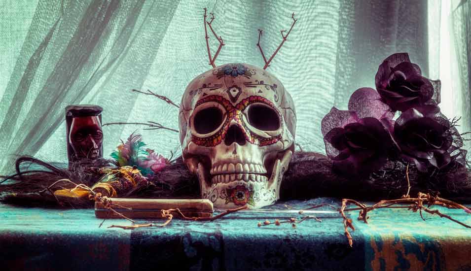 Symbolbild für Hexerei und Vodoo: Ein bemalter menschlicher Schädel liegt auf einem Tisch