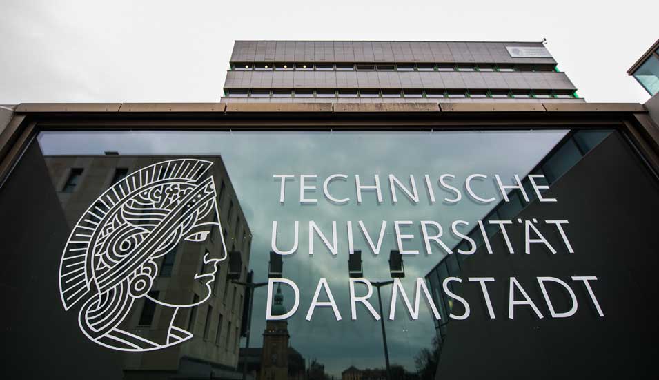 Eine Glasfassade trägt den Schriftzug mit Logo der Technische Universität Darmstadt (TU Darmstadt).