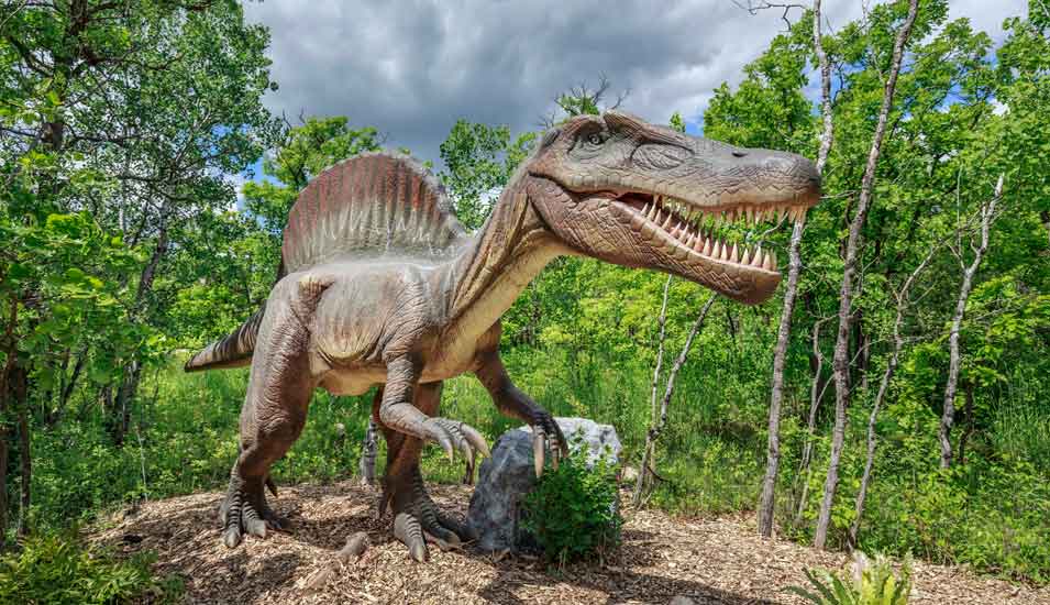 Skulptur eines Spinosaurus in einem Wald in Kanada