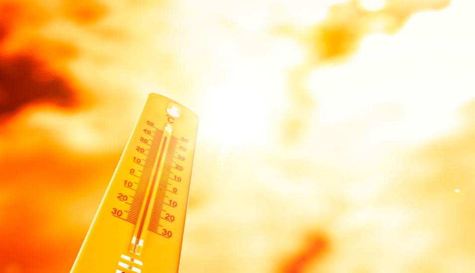 Symbolbild "Hitze": Termometer vor glühendem Himmel