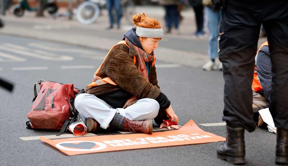Eine Aktivistin und Klima-Kleberin der Letzten Generation hat sich auf der Fahrbahn einer Straße in Berlin festgeklebt, um gegen die Klimapolitik der Bundesregierung zu protestieren.
