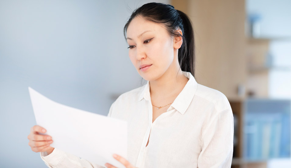 Frau in einem Büro betrachtet Dokumente
