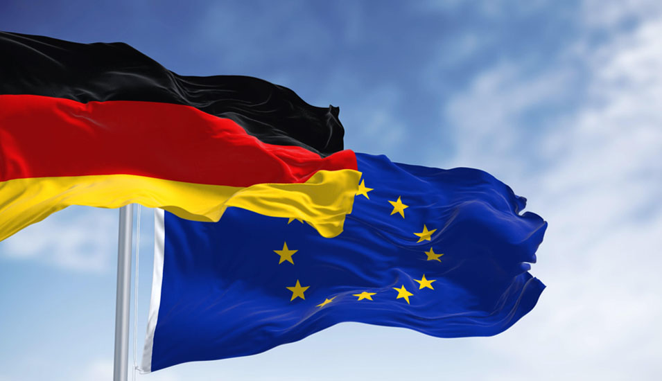 Eine Flagge der Bundesrepublik Deutschland und der Europäischen Union wehen vor einem blauen Himmel