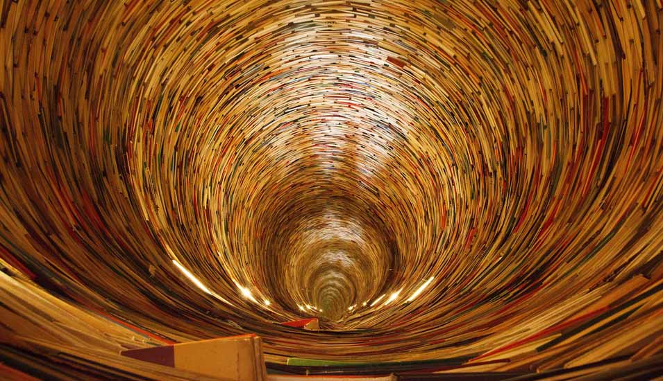 Bücher sind wie in einer Art Tunnel mit Saugwirkung angeordnet. 
