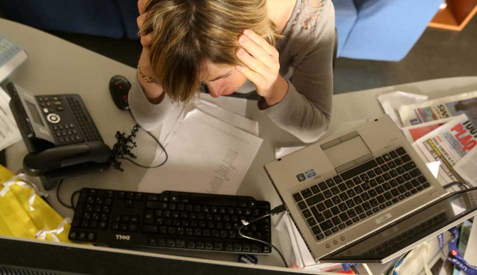 Das Foto zeigt einen Studenten, der müde an seinem Computer sitzt.