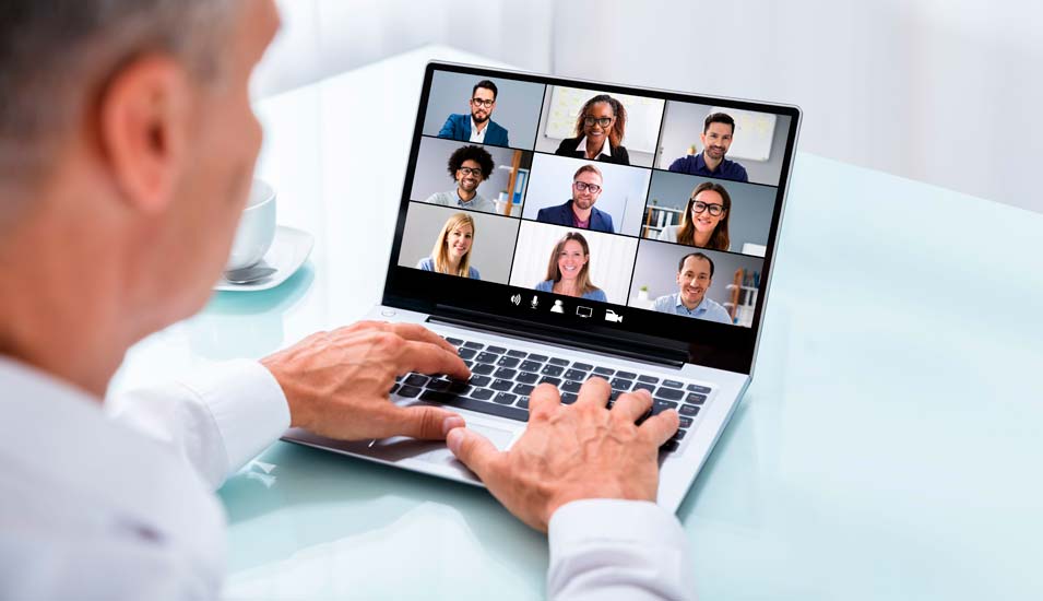Mann nimmt per Laptop an einer Videokonferenz mit 9 Personen teil