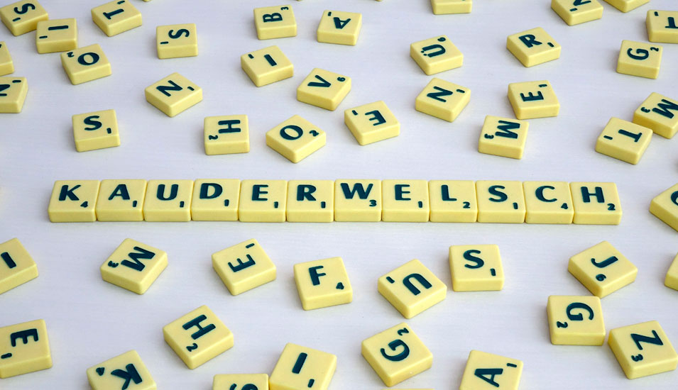 Scrabble Buchstaben sind zum Wort "Kauderwelsch" gelegt.