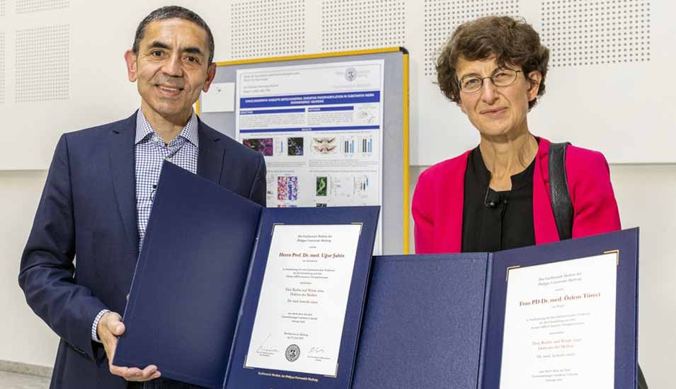 Professor Uğur Şahin und Professorin Özlem Türeci halten die Urkunden für die Ehrendoktorwürde des Fachbereichs Medizin der Philipps-Universität Marburg.