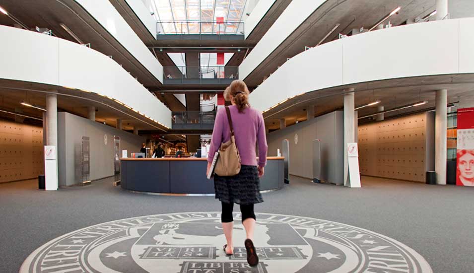 Frau läuft durch Bibliothek der FU Berlin