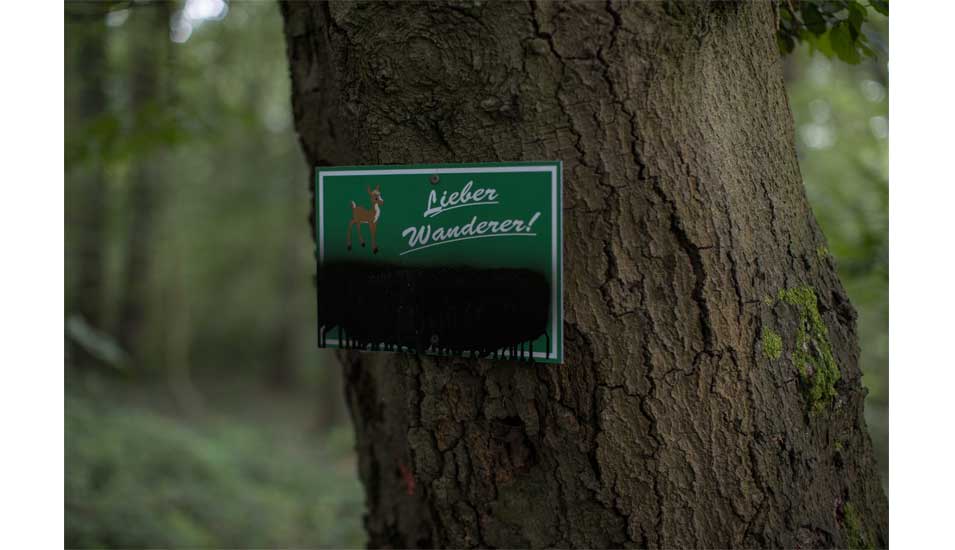 Foto eines Schild an einem Baum mit der Aufschrift "Lieber Wanderer"