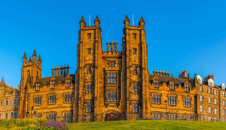 Fassade der University of Edinburgh in der Sonne vor blauem Himmel.
