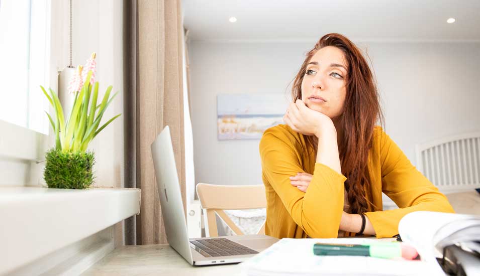 Eine Studentin sitzt zu Hause am Laptop