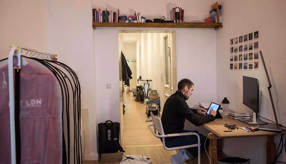 Ein Student sitzt an seinem Schreibtisch in seiner WG in Hannover und lernt.