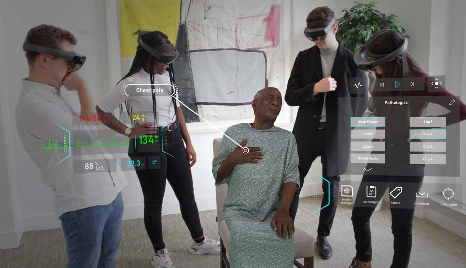 Vier Personen mit Mixed-Reality-Headset betrachten einen Hologramm-Patienten mit Schmerzen in der Brust