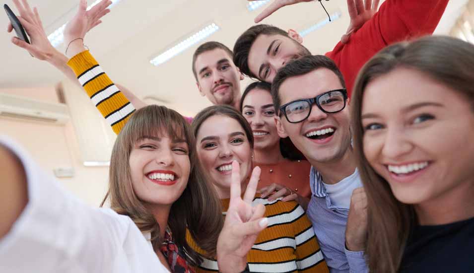Gruppe von internationalen Studierenden posiert für ein Sieger-Selfie