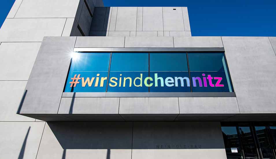 Fassade der TU Chemnitz mit dem Slogan "#wirsindchemnitz" in Regenbogenfarben