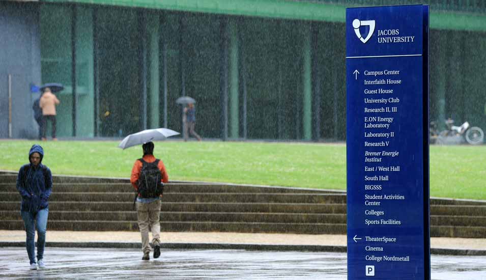 Personen im strömenden Regen auf dem Campus der Jacobs-Universität Bremen
