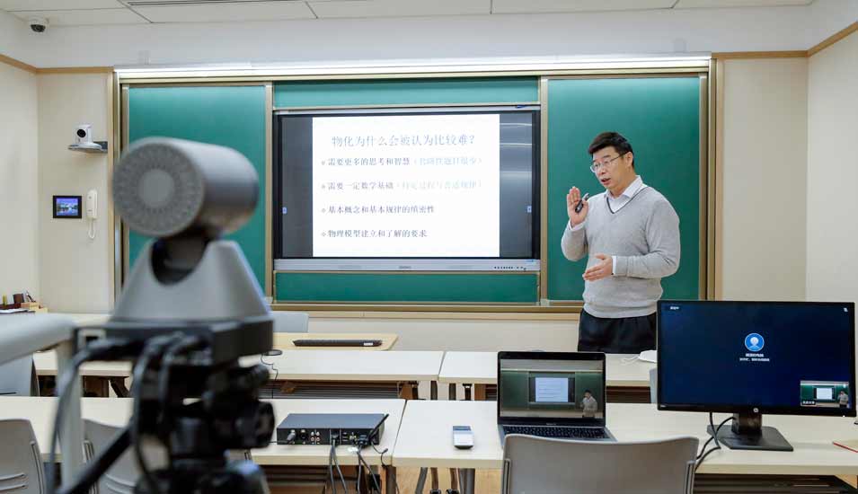 Ein Dozent an der Peking University lehrt per Fernlehre vor einer Kamera in einem leeren Seminarraum.