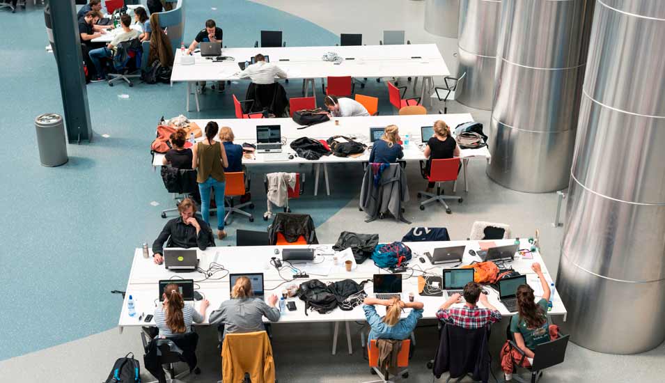 Studierende im Auditorium der TU Delft lernen mit analogen und digitalen Mitteln