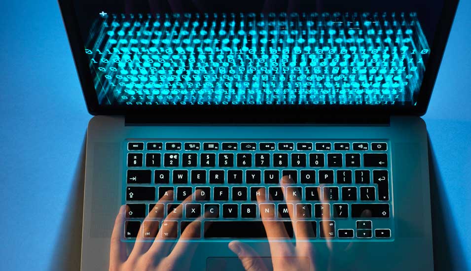 Symbolbild: Die Hände eines Hackers tippen am Laptop.
