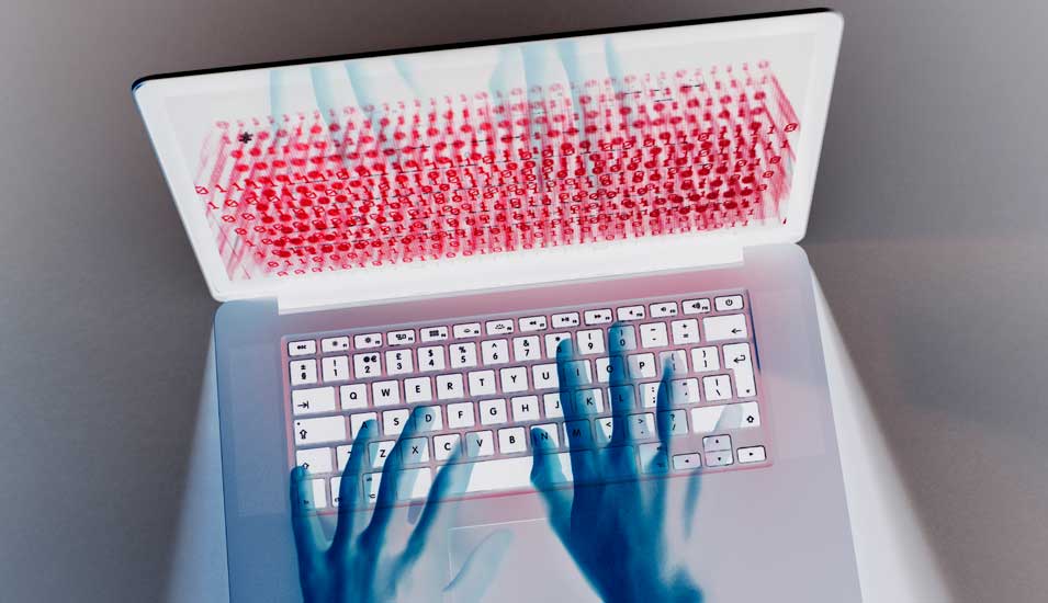 Symbolbild "Cyberkriminalität": die Hände eines Hackers schweben über einer Laptoptastatur