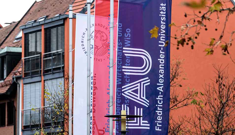 Fahnen der Friedrich-Alexander-Universität Erlangen-Nürnberg mit dem Namen der Hochschule am Standort Erlangen.
