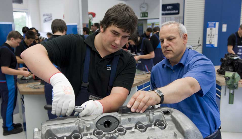 Das Foto zeigt einen Lehrling mit seinem Meister in einem BMW-Ausbildungsbetrieb.