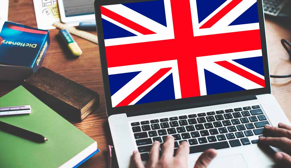 Laptop mit britischer Flagge auf dem Bildschirm und Lernmaterialien auf einem Tisch