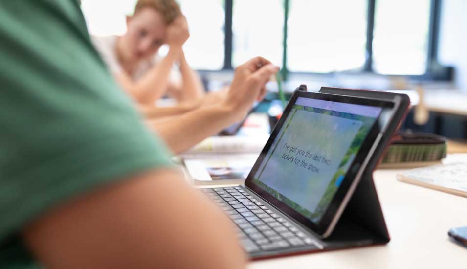 Schüler im Klassenzimmer verwendet Tablet für Sprachunterricht