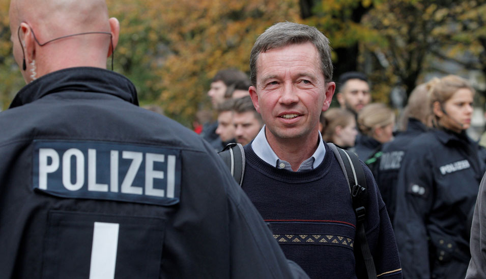 Das Foto zeigt Professor Bernd Lucke geschützt von Polizisten in Uniform