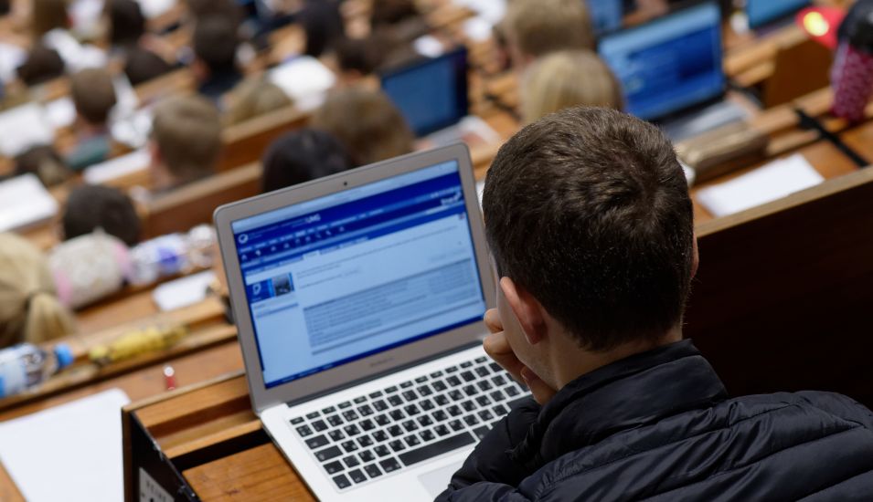 Das Foto zeigt einen Studierenden mit Notebook in einer Vorlesung
