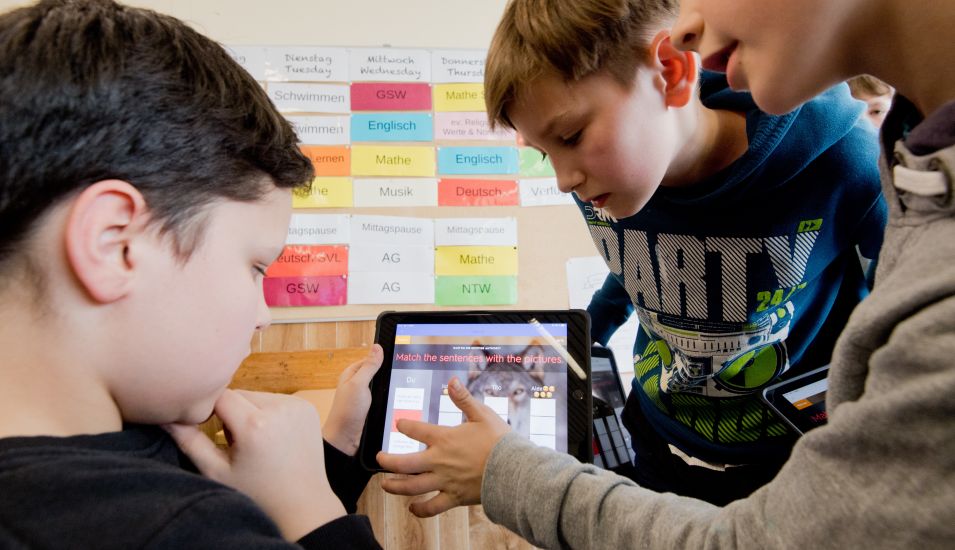Das Foto zeigt zwei Schüler einer fünften Klasse, die mit einem I-pad lernen