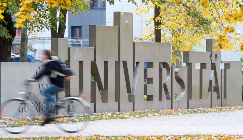 Fahrradfahrer vor dem Eingang zum Campus der Universität Magdeburg