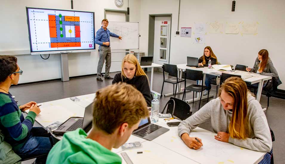 Lehrer und Schüler mit digitalen Lehrformaten in Schule in Rotterdam