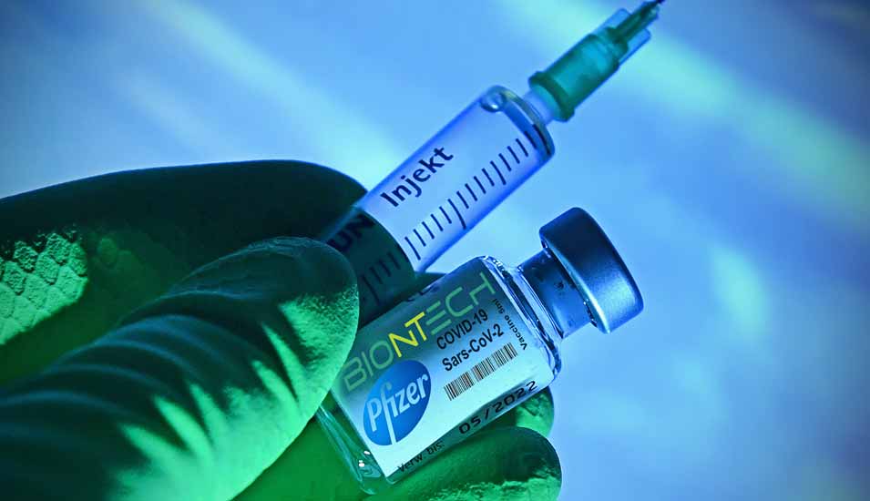 Spritze und Glasgefäß mit Impfstoff von Biontech und Pfizer