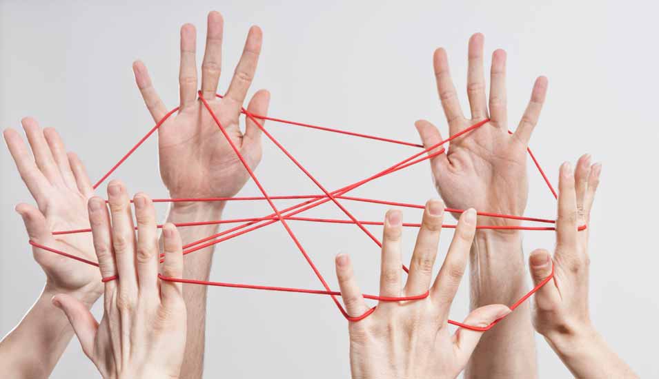 Mehrere Hände bilden ein Netzwerk aus einem roten Faden