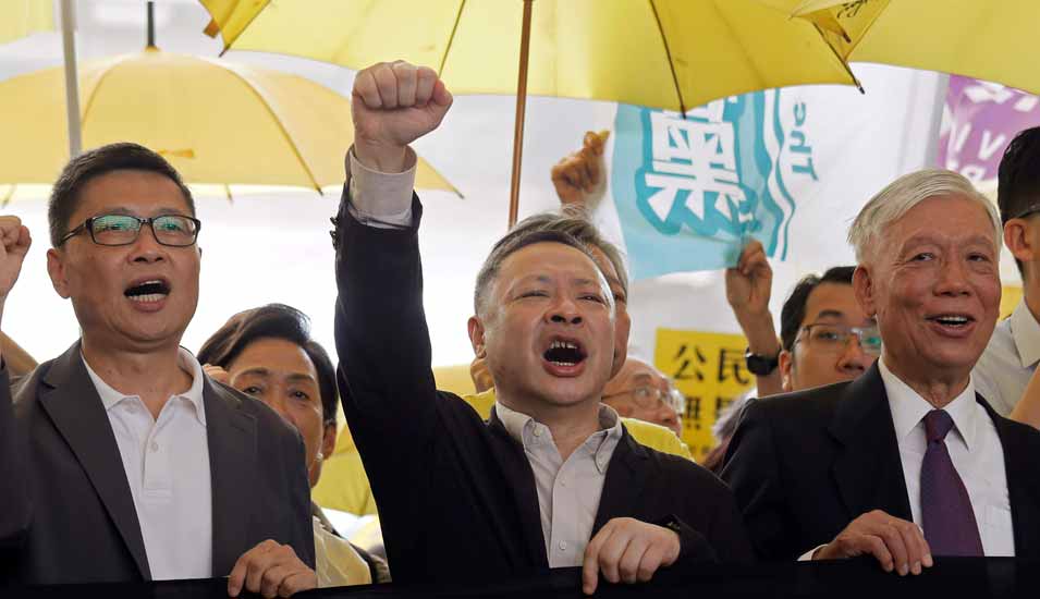 Die Leiter der „Occupy Central“-Bewegung, auch bekannt als „Umbrella Movement“, bei einem Protest im April 2019: Chan Kin-man, Benny Tai (Mitte) und Chu Yiu-ming.
