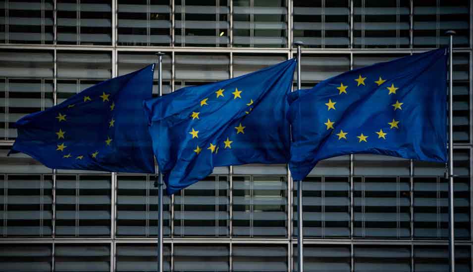 drei wehende Europaflaggen vor dem Sitz der Europäischen Kommission in Brüssel