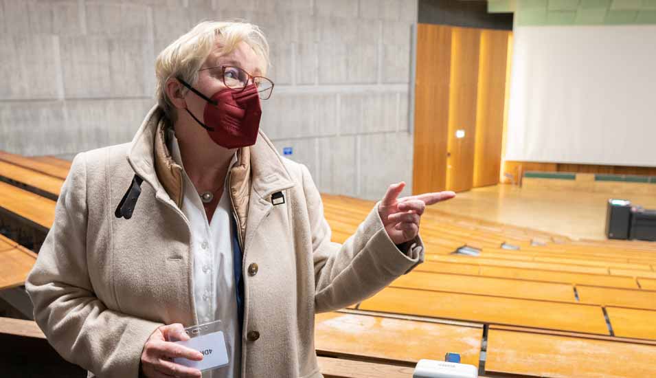 Theresia Bauer, Wissenschaftsministerin von Baden-Württemberg, steht mit FFP2-Maske in einem Hörsaal der Universität Stuttgart.