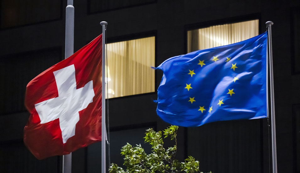 Schweizer Fahne weht neben der Fahne der EU.