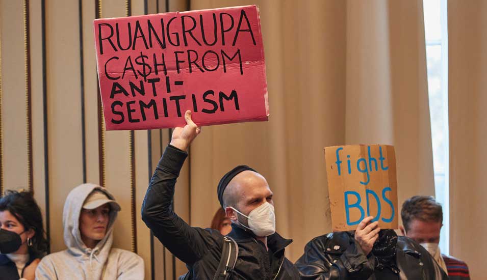 Protestierende halten Schilder hoch, u.a. mit der Aufschrift "Ruangrupa cash from Antisemitism"