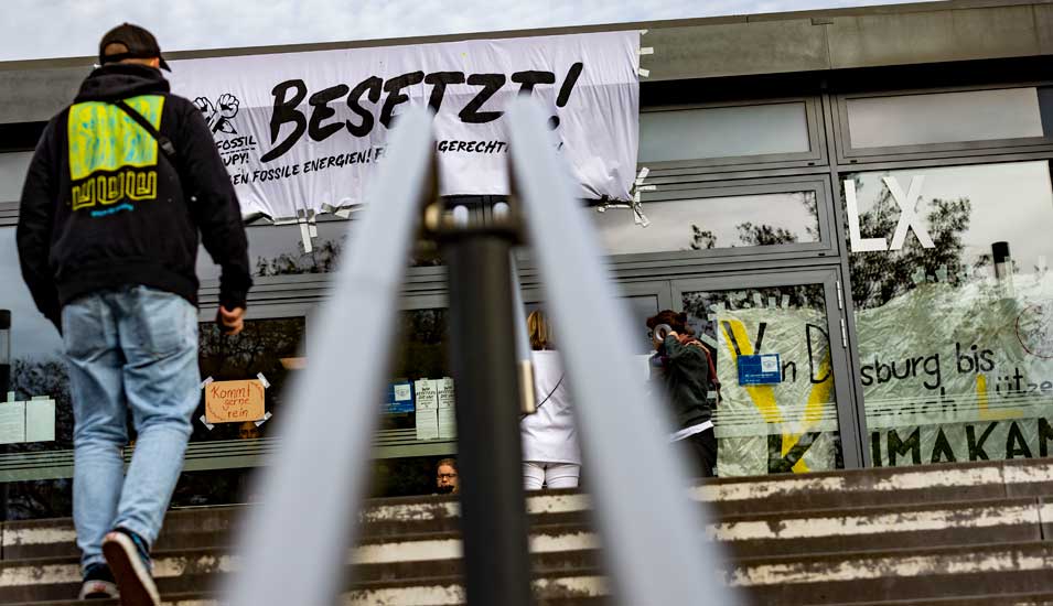 Ein Banner mit der Aufschrift "Besetzt" hängt über dem Eingang zum Gebäude LX der Universität Duisburg. 