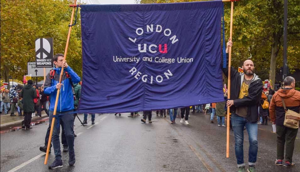 Demonstranten halten ein Banner des Londoner Zweigs der Gewerkschaft University and College Union (UCU).
