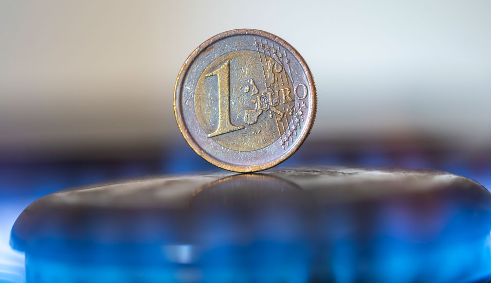 Ein-Euro-Münze auf einem Gasherdkochfeld.