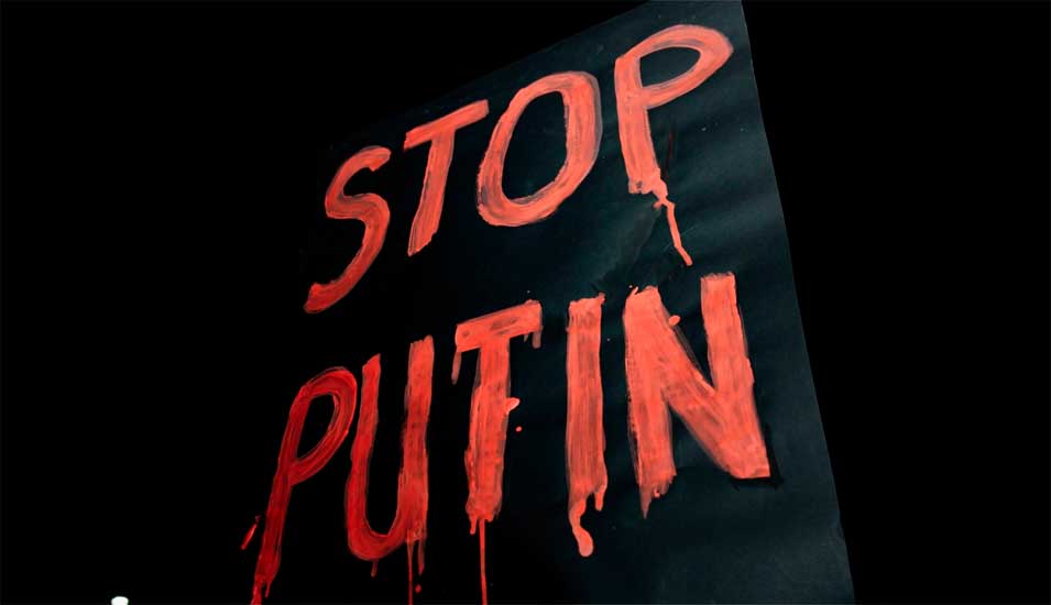 Foto eines Protestplakats mit der Aufschrift Stop Putin in roter Schrift auf schwarzem Grund