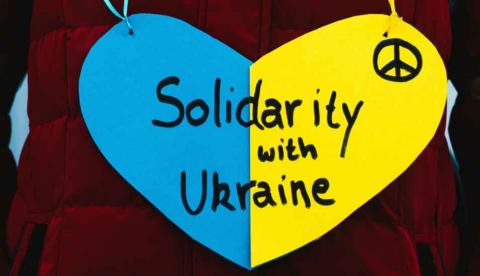 Schild in Herzform in den Farben der ukrainischen Flagge mit einer schriftlichen Solidaritätsbekundung
