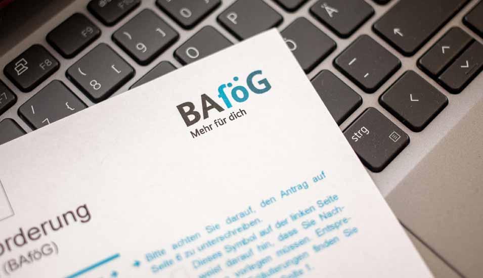 Ein Antrag auf Ausbildungsförderung (Bafög) liegt auf der Tastatur eines Laptops.