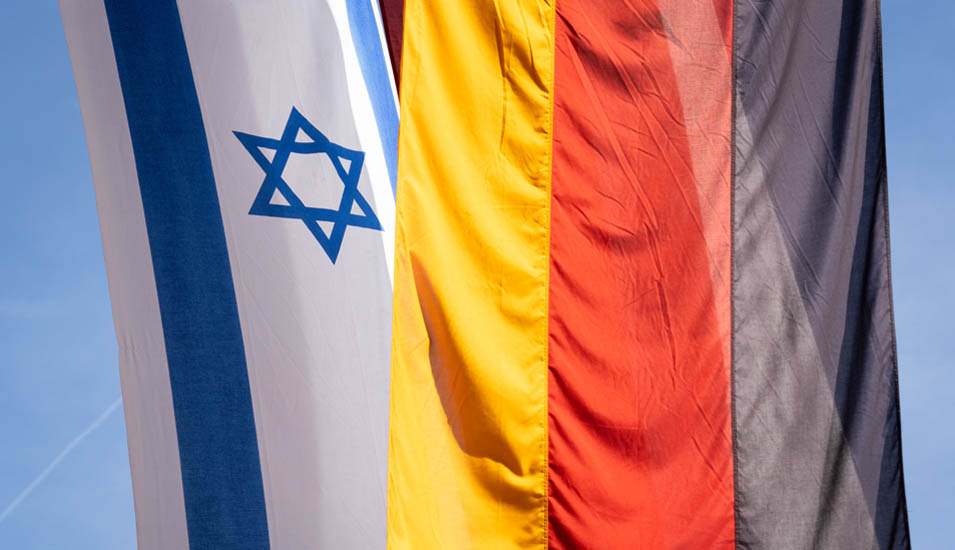 eine israelische und eine deutsche Flagge vor einem blauen Himmel