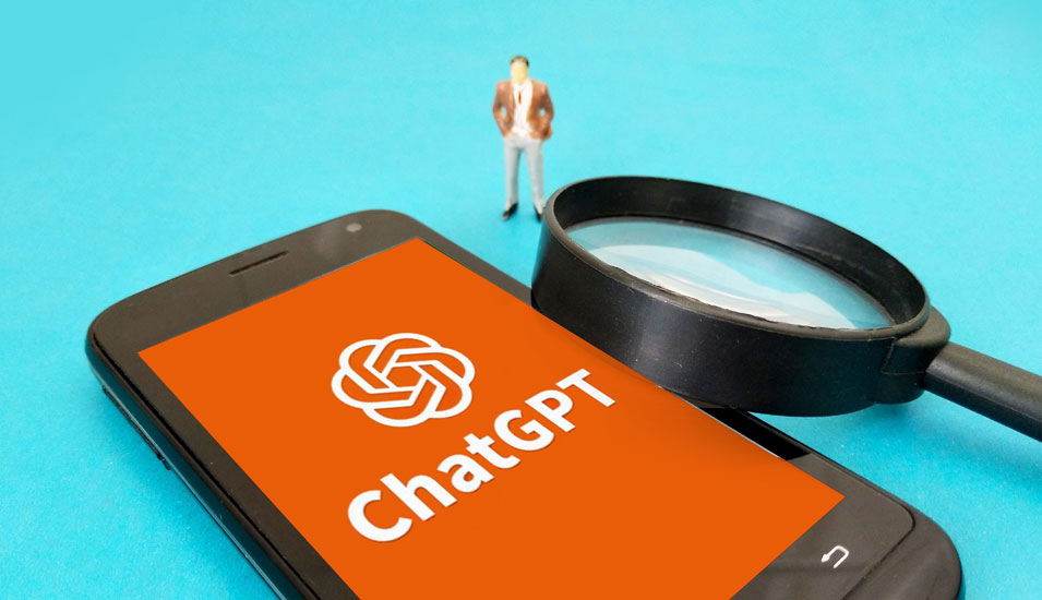 Ein Smartphone, eine Lupe und eine menschliche Figur. Auf dem Telefonscreen das Logo "ChatGPT". Symbolbild.