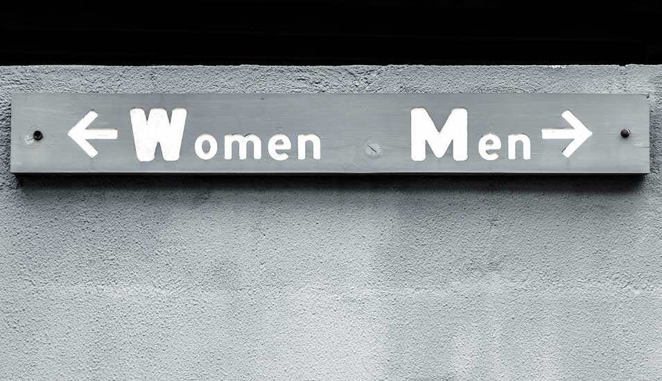 Symbolbild Geschlechtertrennung: Hinweisschilder nach rechts und links mit der Aufschrift "Männer" und "Frauen".